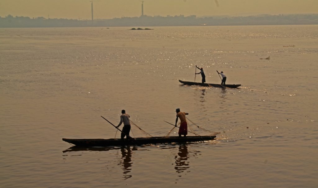 Kinshasa - fishermen on the Congo river. Brazzaville in the background