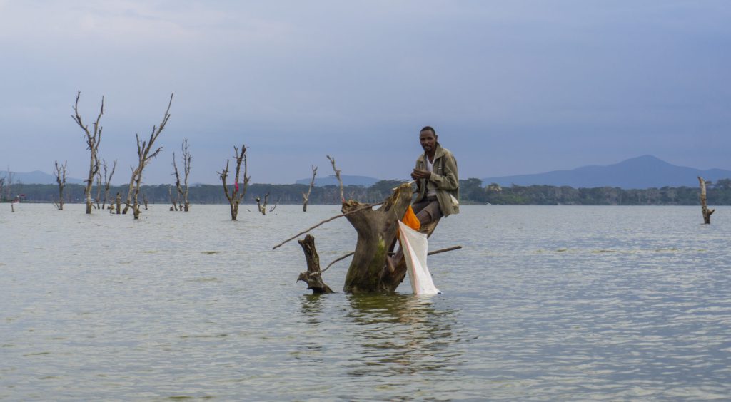 A fisherman on a tree trunk in Lake Naivasha - Waiting for the catch of the day